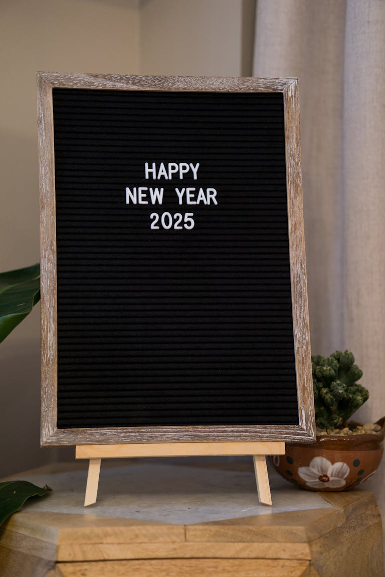 Festive message board with 'Happy New Year 2025' text displayed indoors.